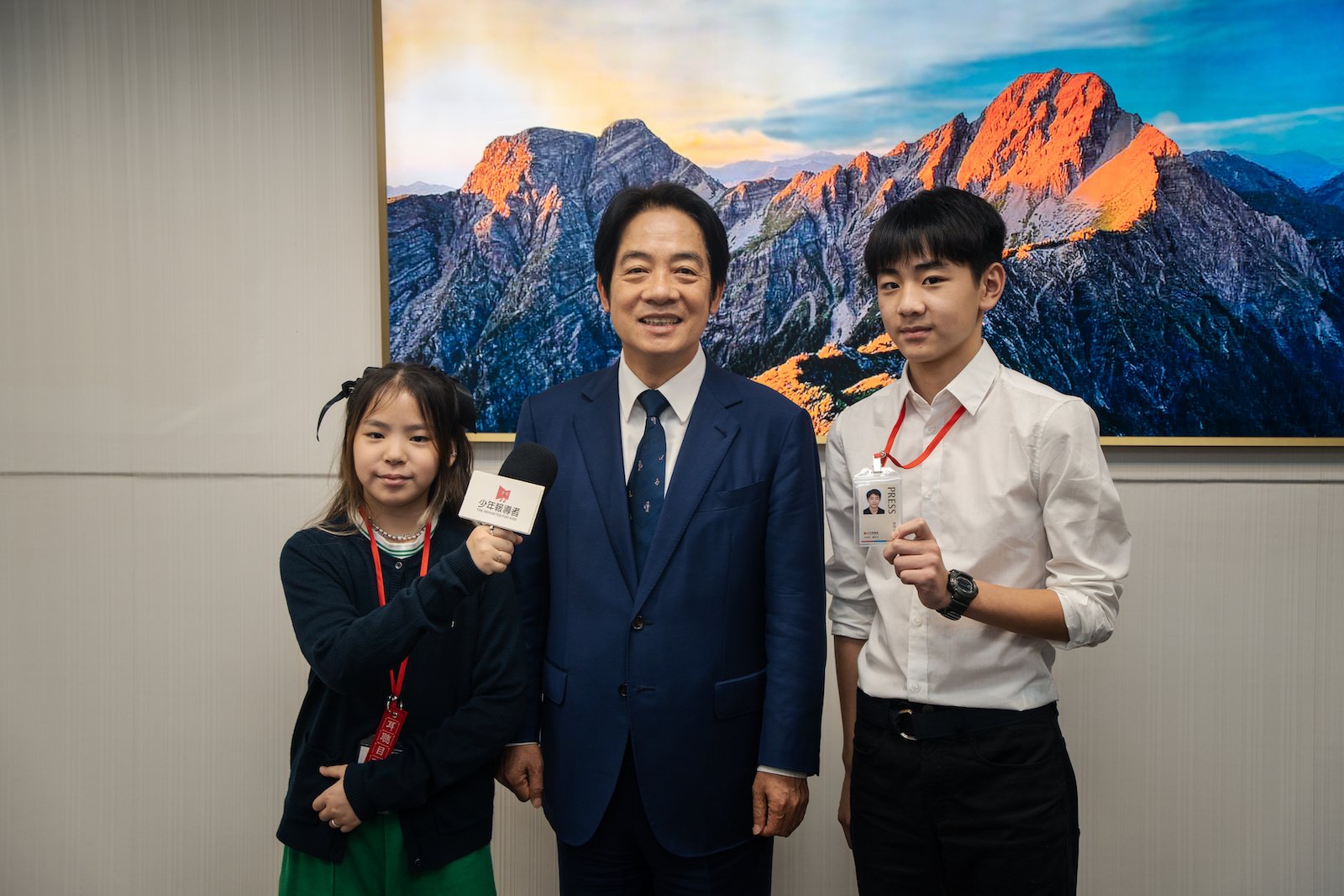 《少年報導者》小記者莫雅欣（左）、蕭亞凡（右）與賴清德合影。（攝影／王崴漢）