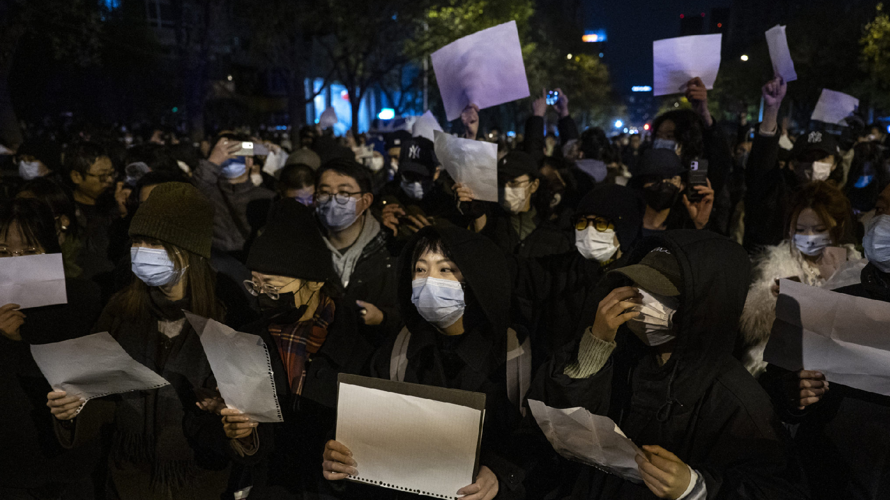 2022年11月底，中國新疆烏魯木齊火災事件引爆中國民眾對疫情極端封控的不滿，隨後在中國各大城市乃至海外都出現了「白紙抗議」浪潮，圖為北京民眾舉著白紙走上街頭。 （攝影／Kevin Frayer／Getty Images）