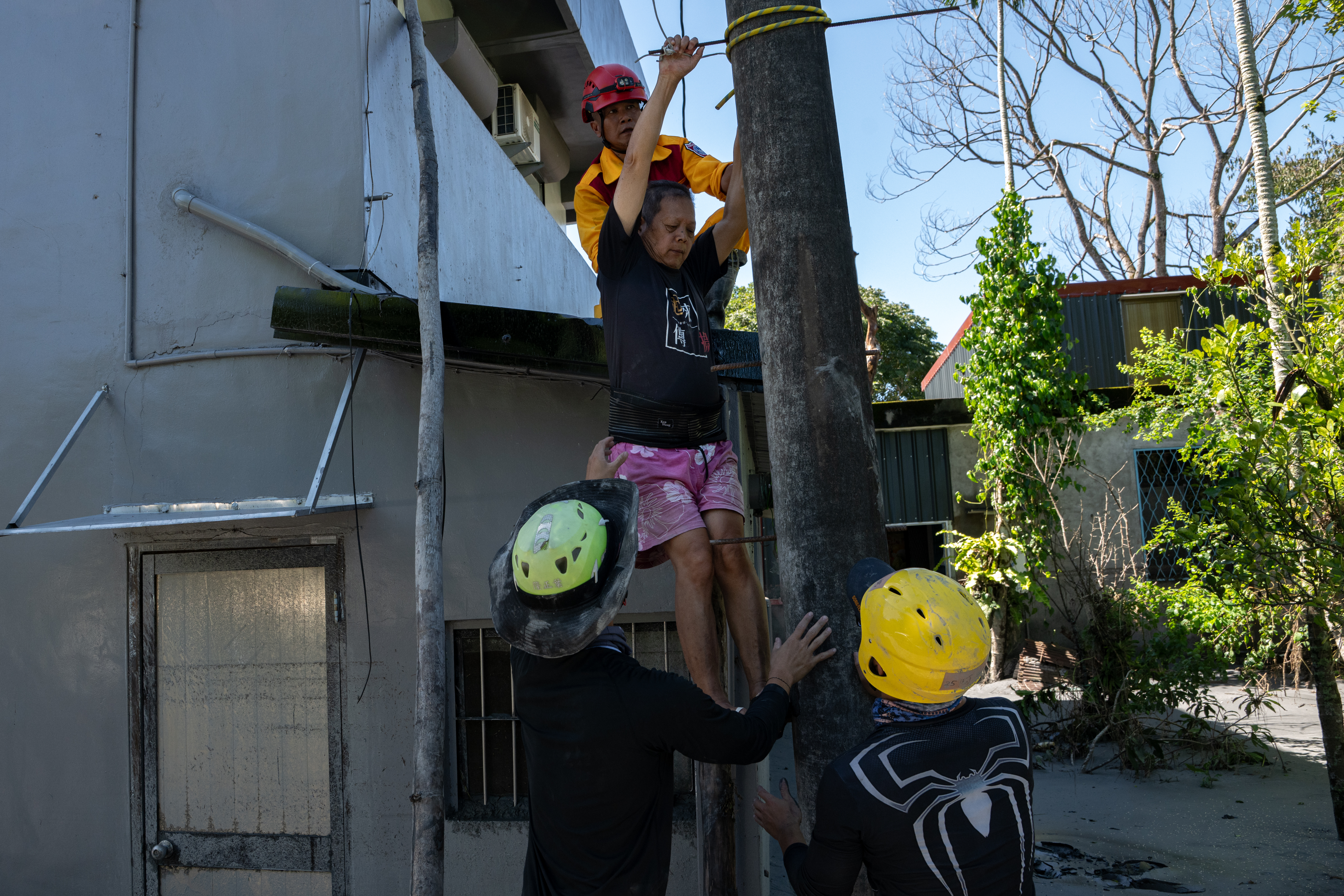 2025年9月24日上午，佛祖街有一夫妻原選擇於二樓垂直避難，後因沒有水電而求救，搜救隊協助其自二樓撤離。（攝影／謝佩穎）