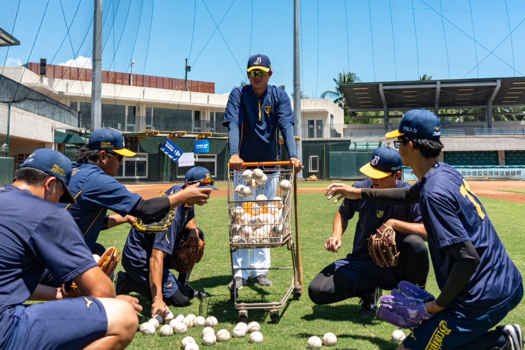 結束投手守備練習，王建民與年輕選手一起收拾球具。（攝影／陳曉威）