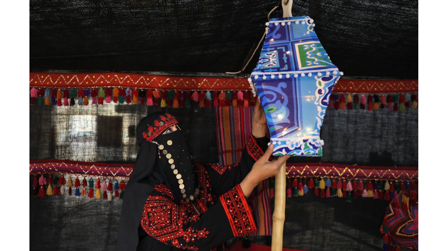 一名巴勒斯坦加薩市的穆斯林婦女掛起「Fanous」燈籠，慶祝即將開始的齋戒月。（攝影／MOHAMMED ABED／AFP）