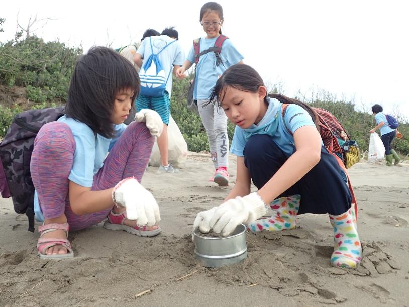 淨灘時，志工們會用篩子篩出塑膠微粒，從中了解到塑膠難以分解的問題。（圖片提供／劉豫瑄）