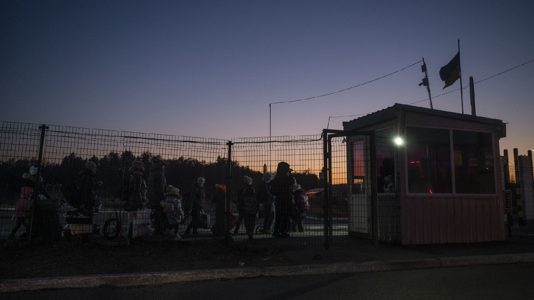 2022年3月13日傍晚，在烏克蘭與波蘭的邊境關口，一群帶著孩子的女性正要徒步通過國界。俄羅斯入侵烏克蘭戰爭爆發後，烏克蘭限制18至60歲的男性公民離境，因此逃亡的隊伍中多數都是母親與孩子。（攝影／楊子磊）