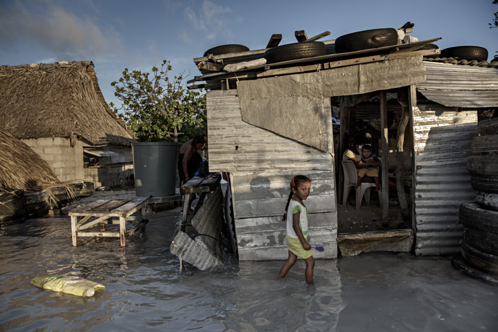 吉里巴斯許多島嶼僅比海平面高出幾英尺，由於海平面持續上升，吉里巴斯人民面臨搬遷的壓力。圖為2015年一個小女孩涉過淹沒村莊的海水。 （攝影／LightRocket via Getty Images／Jonas Gratzer）