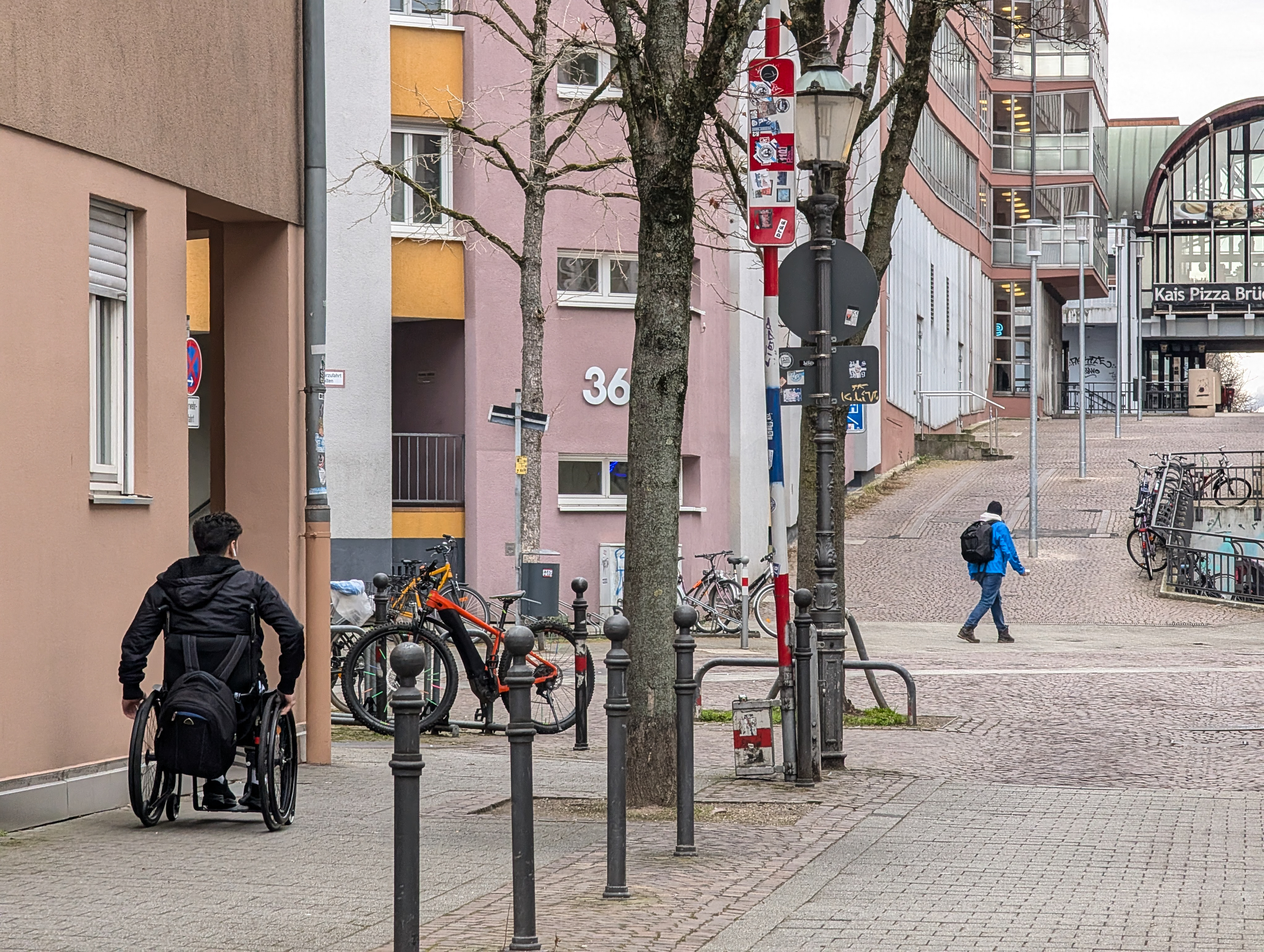 行動不便者日常通行面臨著各式挑戰，因此無障礙設施在城市空間中十分重要。圖為2025年2月24日，一位輪椅使用者行經德國巴登符騰堡州卡爾斯魯厄市的人行道。（攝影／MICHAEL NGUYEN / NurPhoto／AFP）
