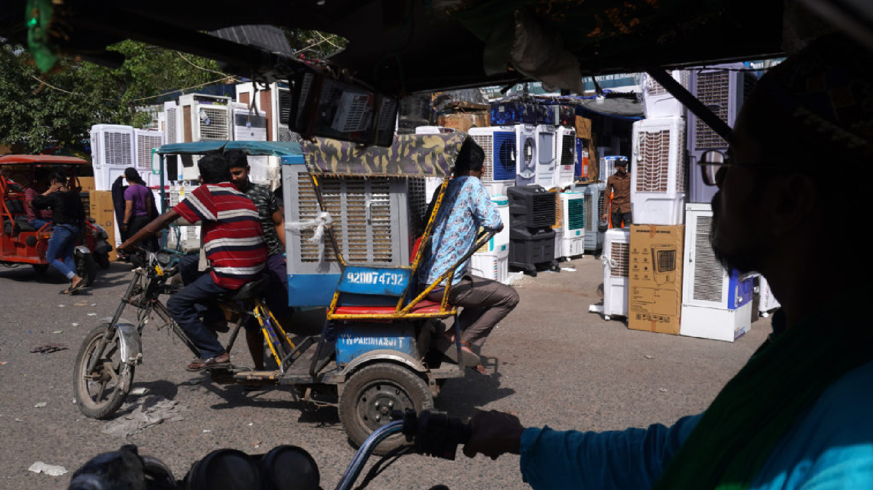 夏天的印度，人力車司機為了在熱浪襲擊下維持生計，紛紛在後座加上冷氣機。（攝影／NurPhoto via Getty Images／Mayank Makhija）