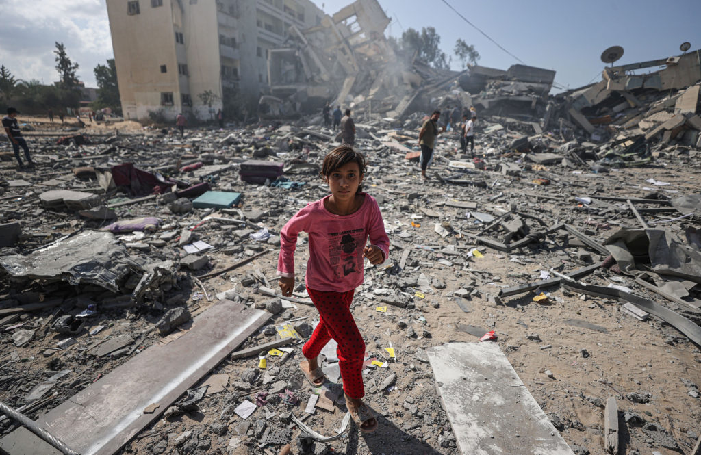 A girl walks amid the rubble of residential buildings after Israeli airstrikes at al-Zahra neighborhood in Gaza Strip on October 19, 2023. (Photo by Mustafa Hassona / Anadolu via Getty Images)