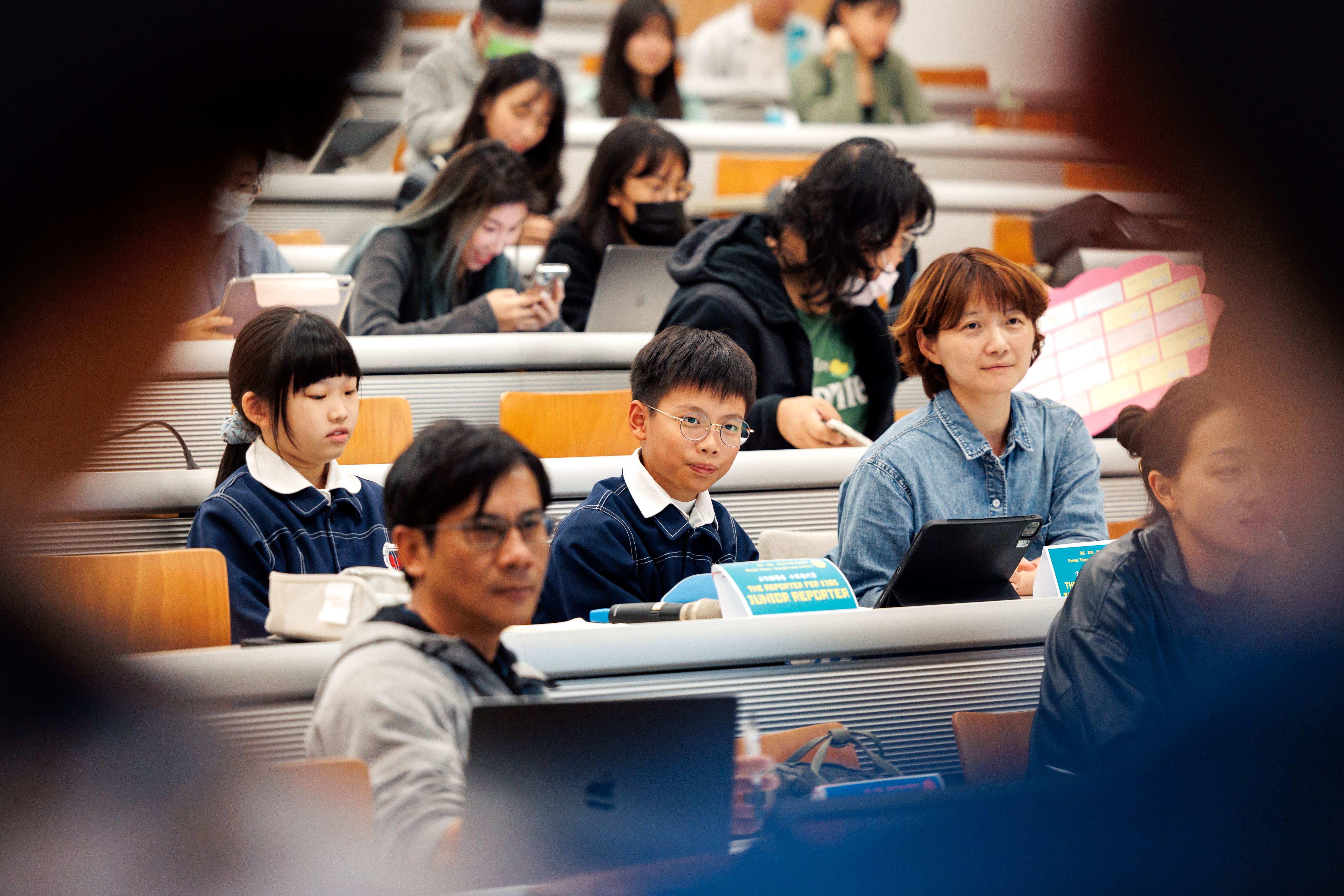 再興小學六年級的鄭安妤(圖左)、李昕祐(圖中)接下任務,幫台大學生期末報告評分。(攝影/鄭宇辰)