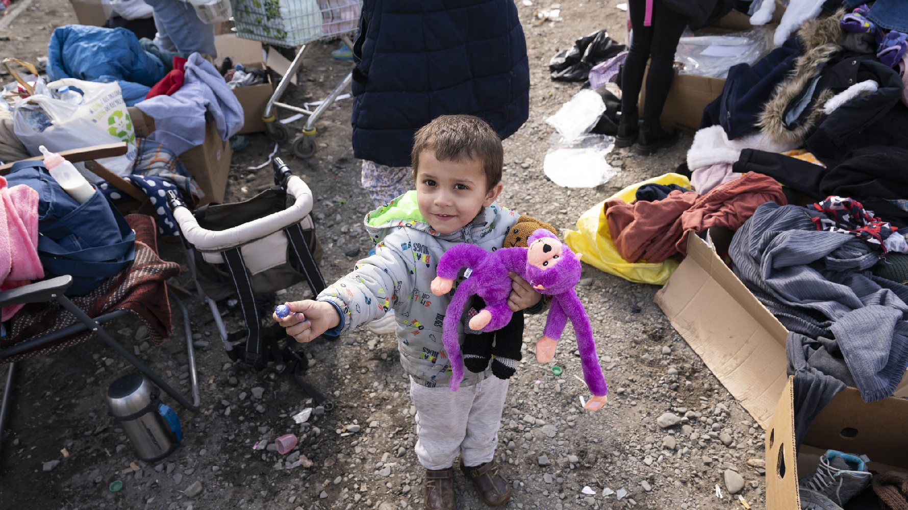 在梅迪卡的一處公路旁的物資站，一個抱著布偶的烏克蘭孩子試圖與人分享他手中的糖果。（攝影／楊子磊）