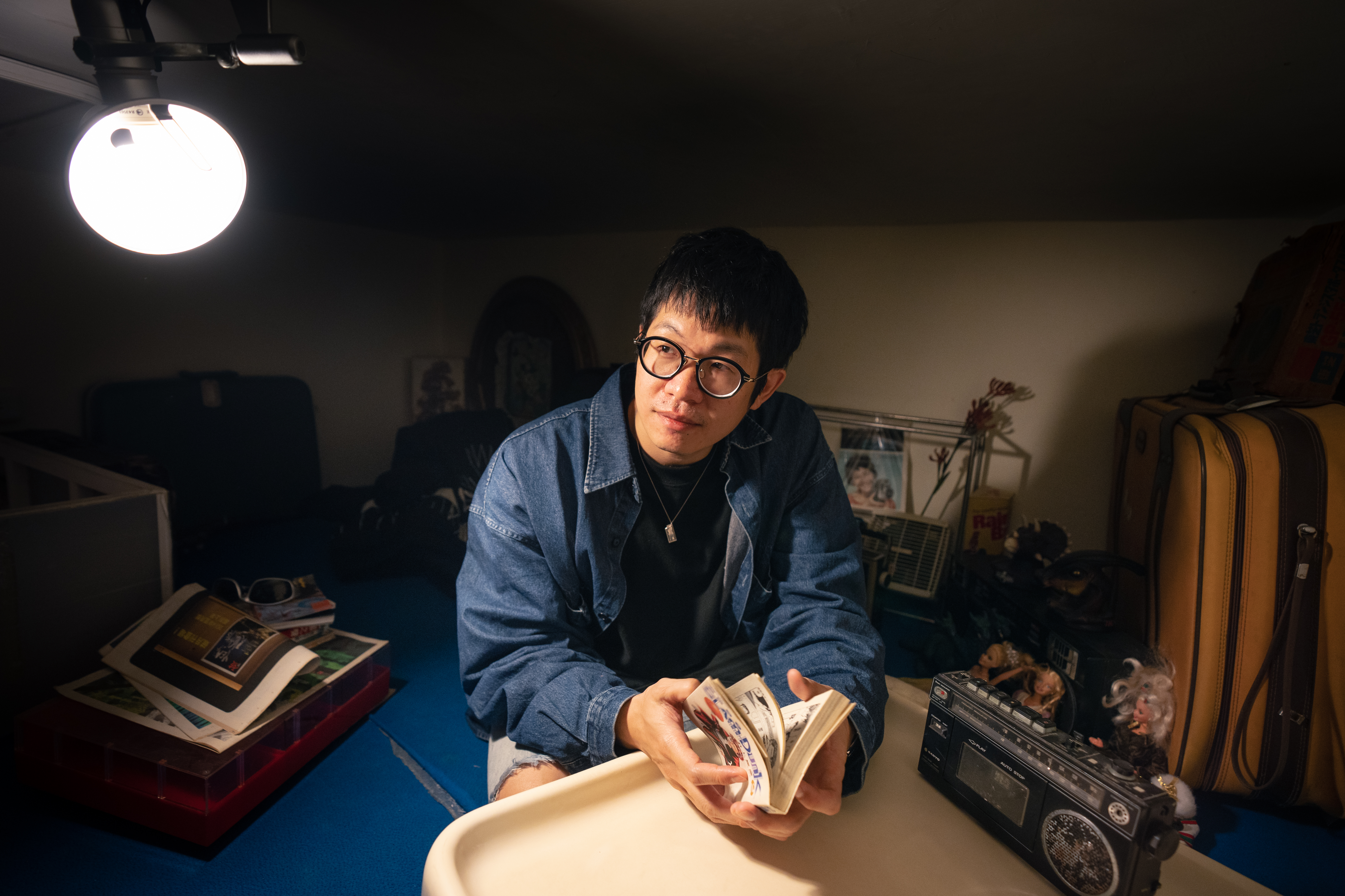 透過畢業紀念冊，黃少雍回憶起自己年少時期的生活景象。（攝影／王崴漢）