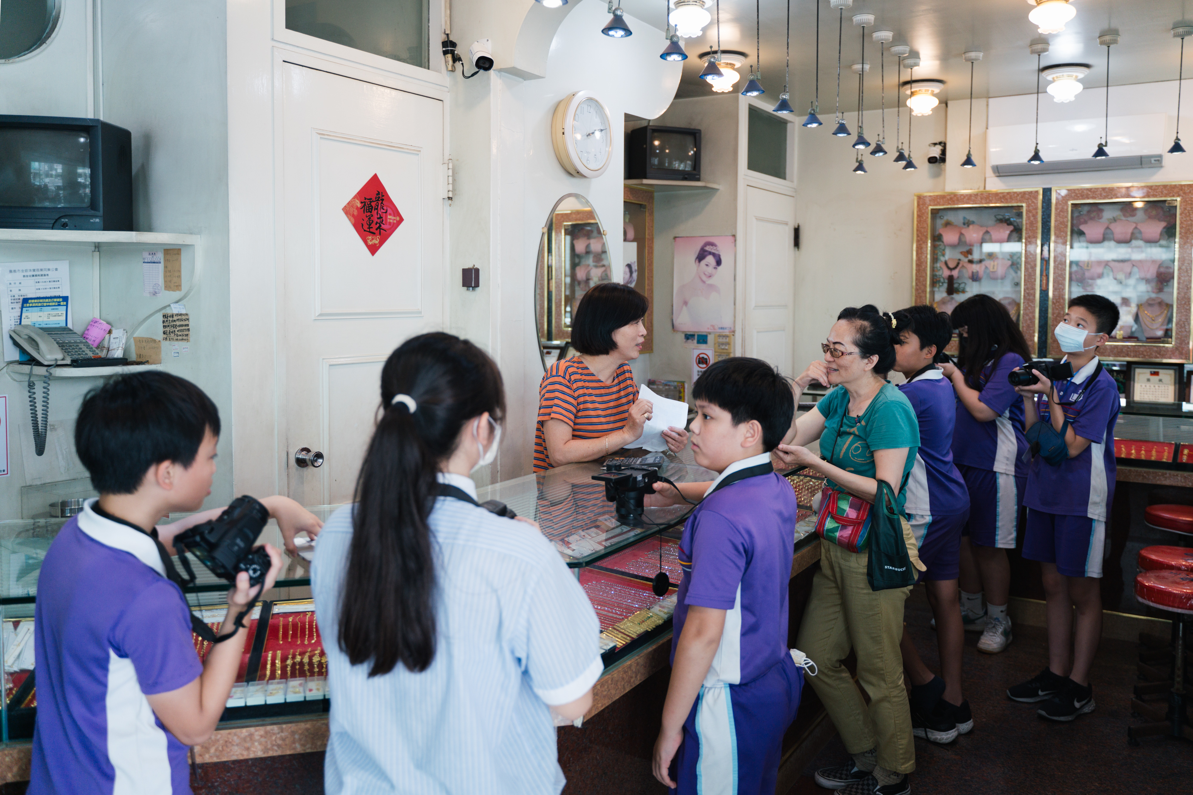 同學跟老師正在採訪金豐成銀樓的老闆娘。（攝影／古佳立）