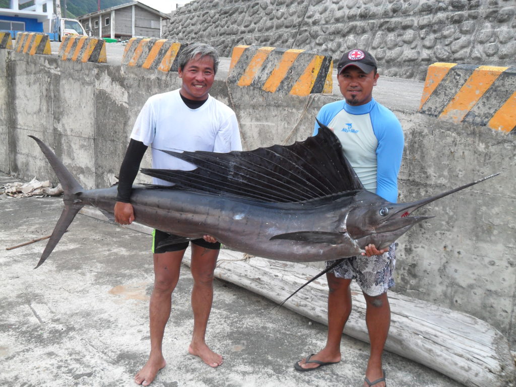 希.瑪巴諾的爸爸(右)與朋友曾經捕到了一條比人還大的旗魚。(圖片來源/希.瑪巴諾的媽媽提供)