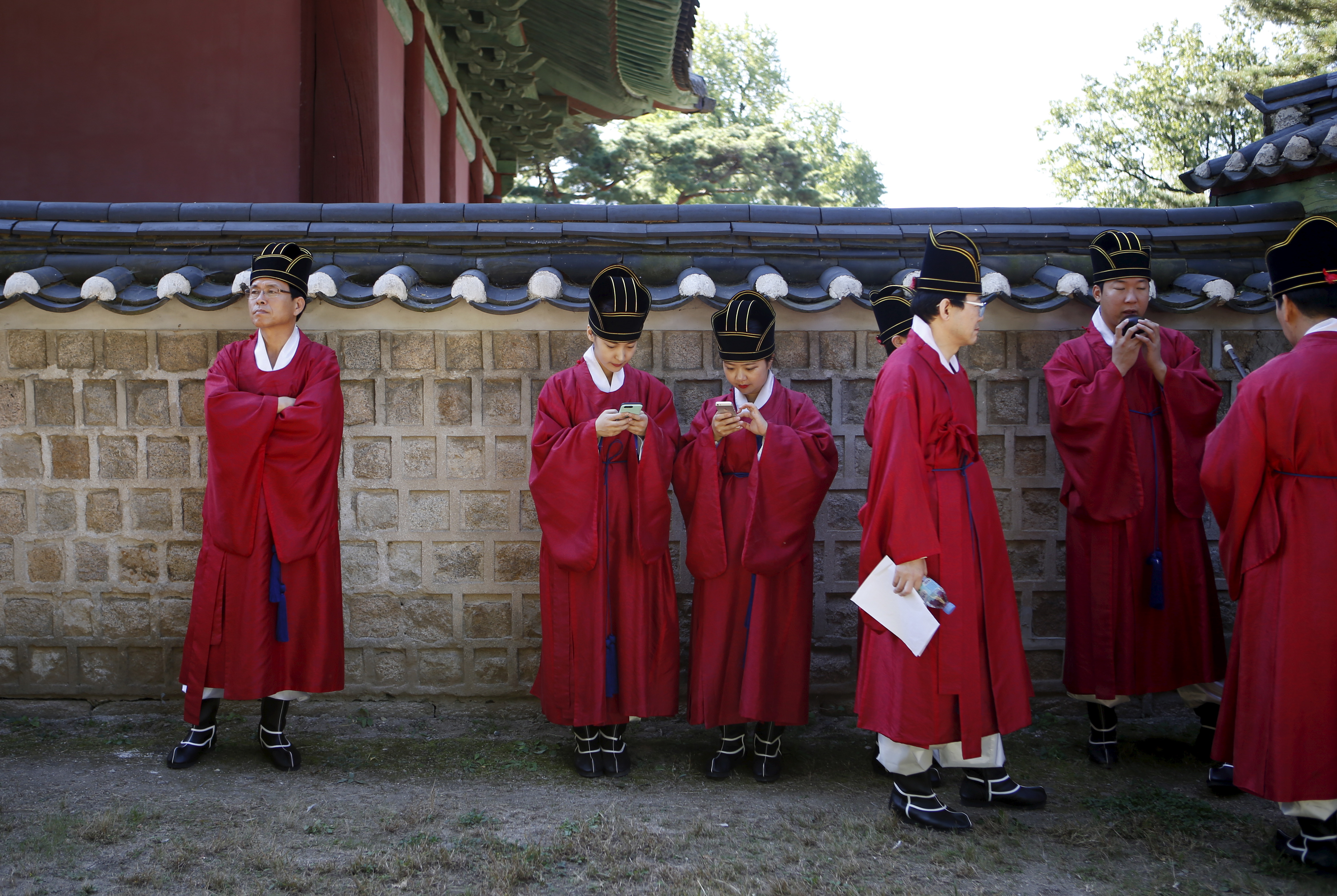 2024年,韓國首爾的學生在參加祭孔典禮前,身著傳統服飾使用手機。(攝影/Kim Hong-Ji/Reuters/達志影像)