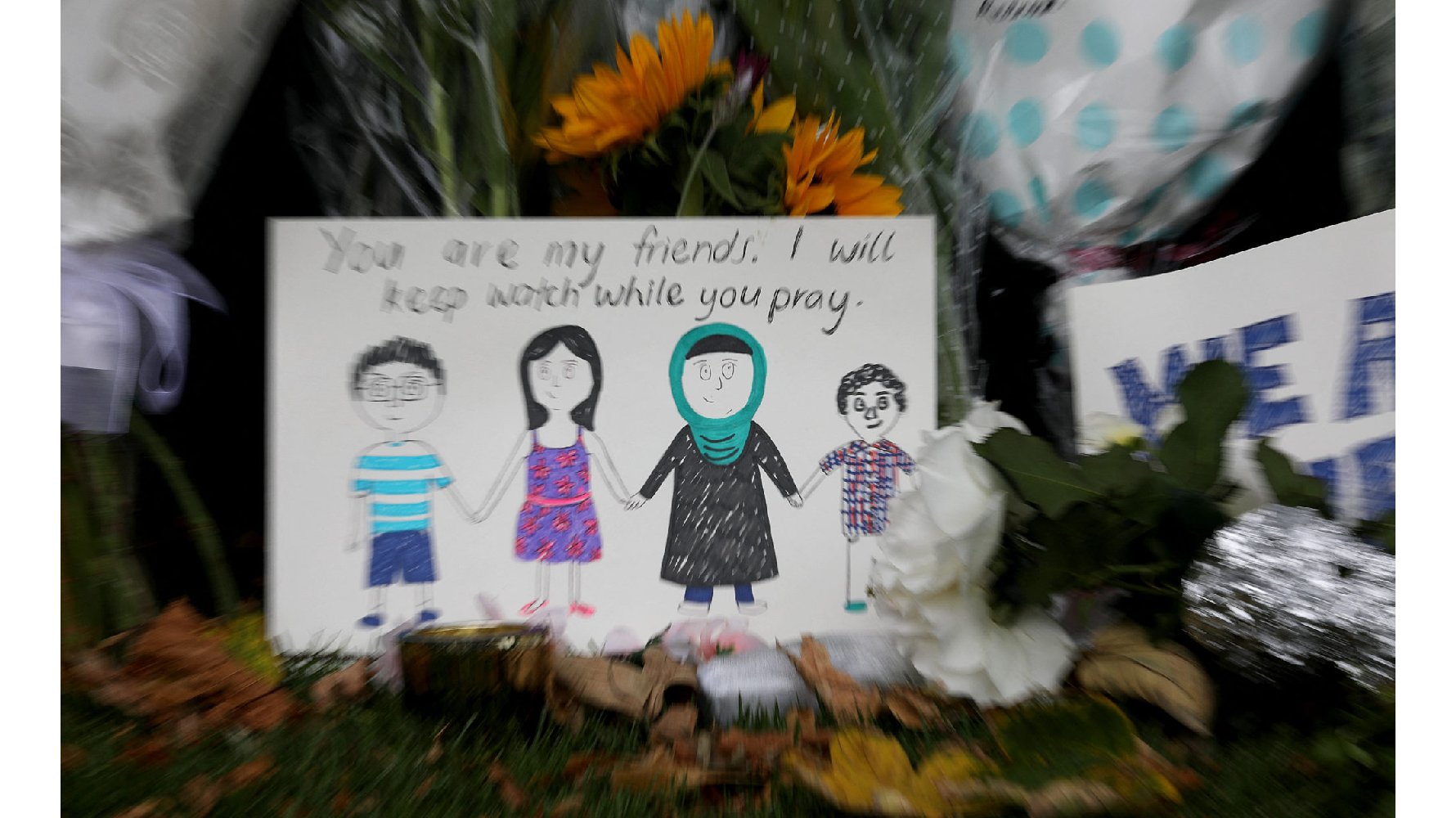 2019年3月17日，在紐西蘭基督城植物園的牆邊擺著民眾對清真寺襲擊受害者的鮮花和對穆斯林的哀悼信。（攝影／NurPhoto via AFP／Sanka Vidanagama）