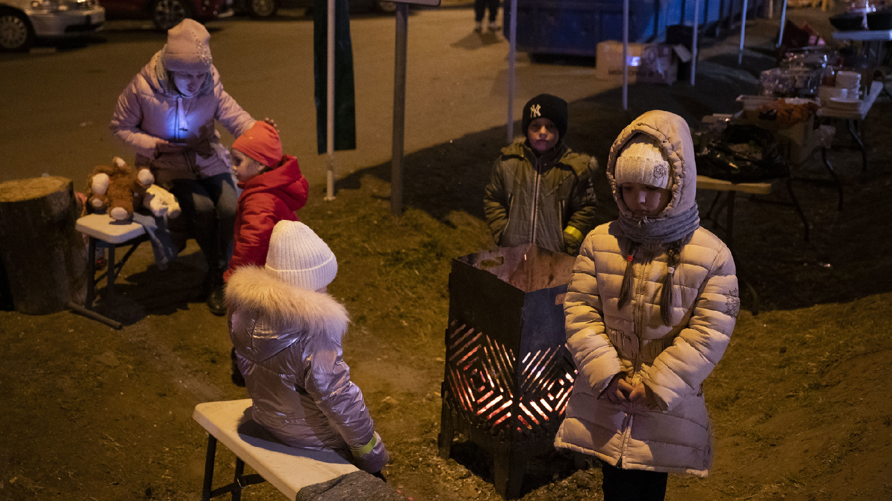 3月13日，在氣溫接近零度的深夜裡，一群剛抵達波蘭國境的烏克蘭孩子在公路旁烤火取暖。（攝影／楊子磊）