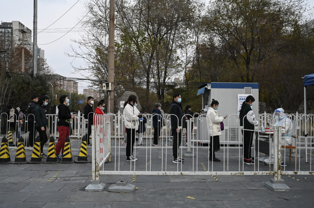 北京市區的民眾於街區的篩檢站排隊等候核酸檢測。(攝影/AFP/Jade Gao)