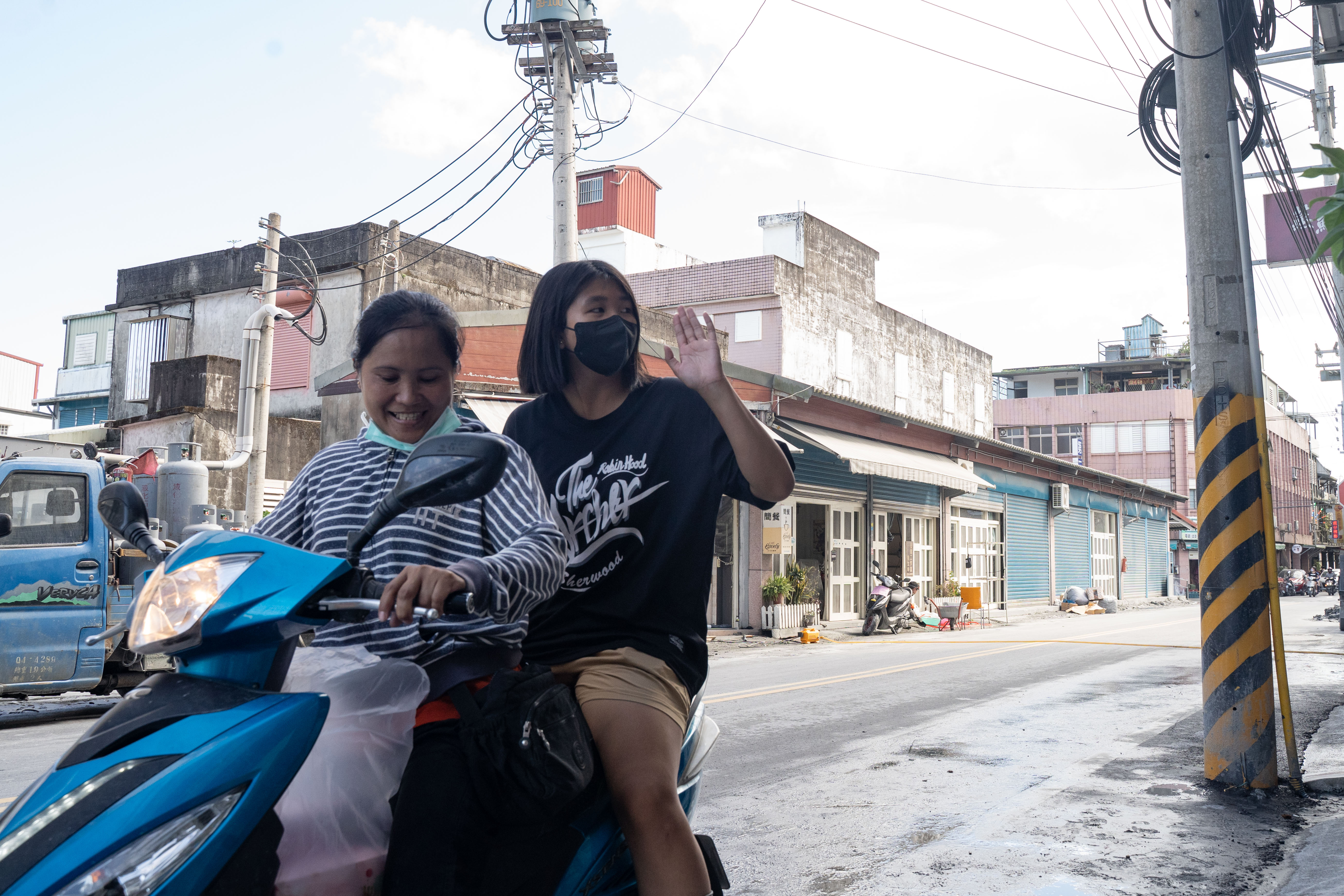 新住民媽媽領到物資任務後，載著小孩一同送暖。（攝影／唐佐欣）