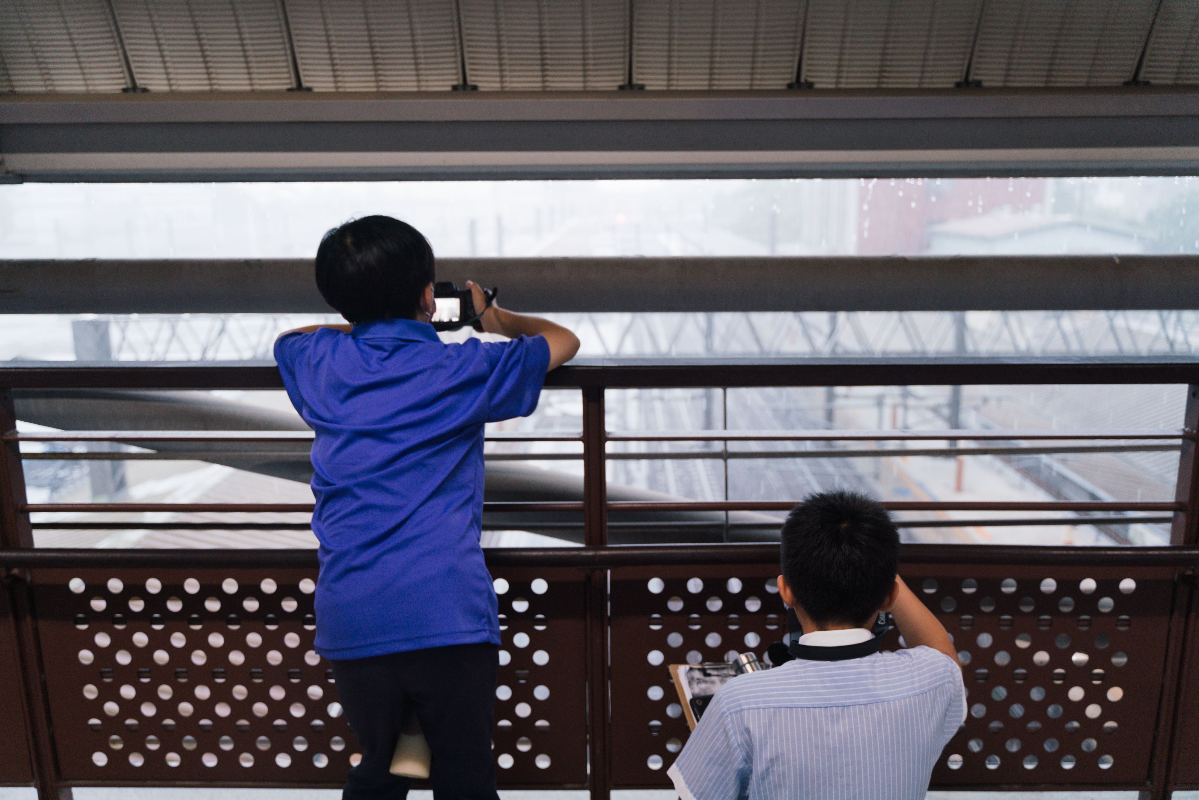 同學於嘉義火車站的天橋上進行拍攝。（攝影／古佳立）