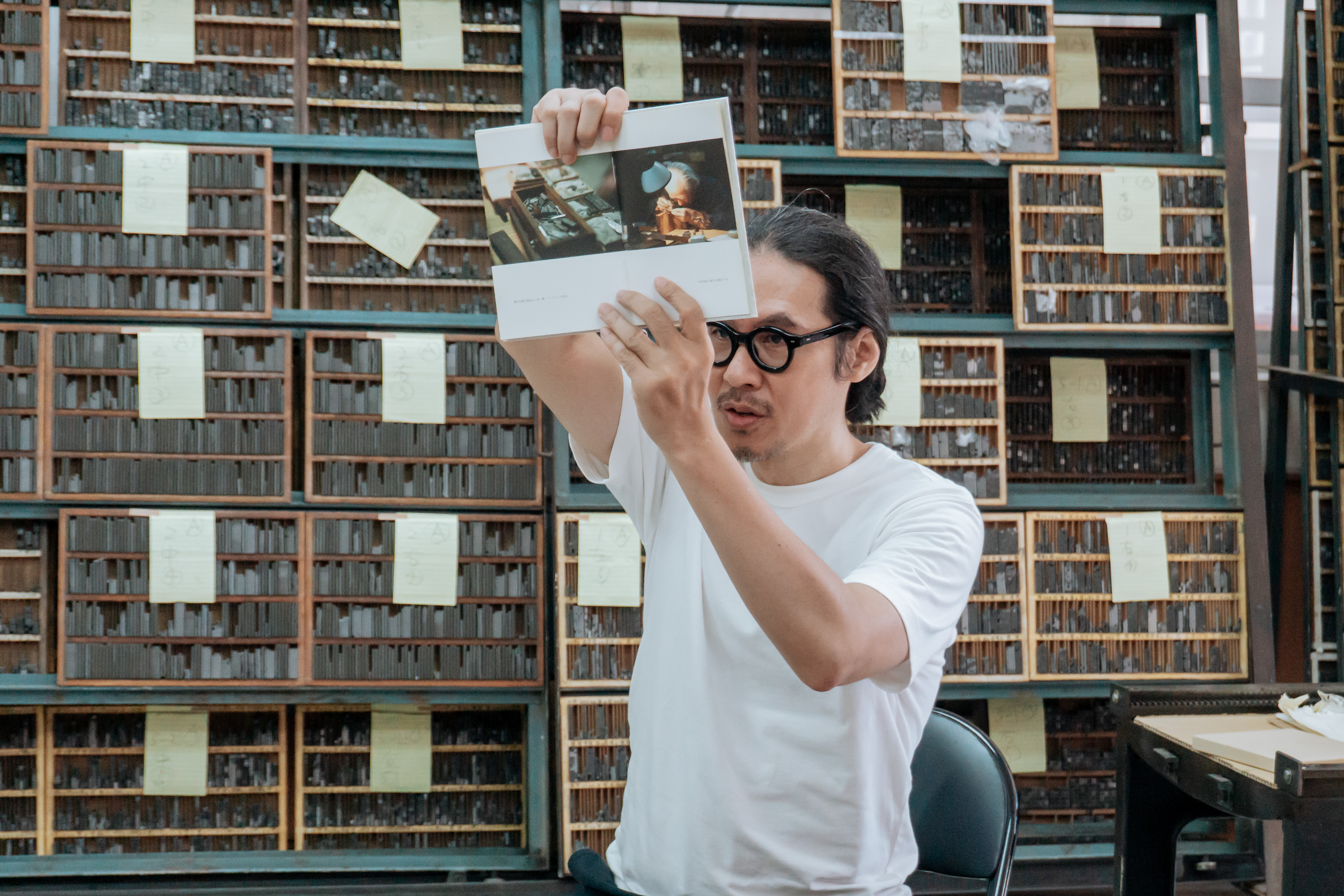 高鵬翔去過許多老師傅的工作現場，他用影像、文字與手繪細心描繪活字工作。圖為分享介紹日本老師傅雕刻種字的書籍。（攝影／陳柏羽）