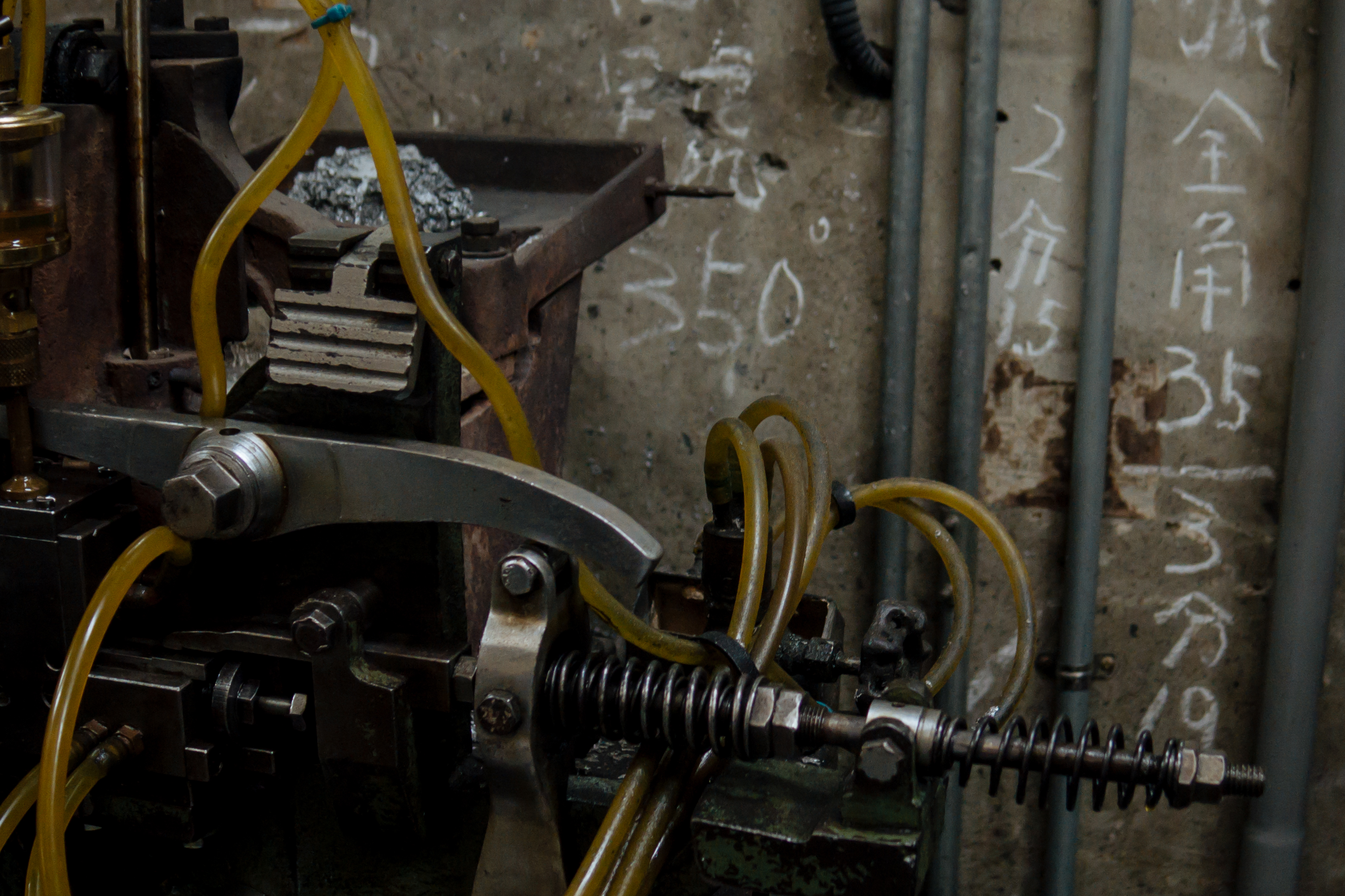 日星鑄字行一樓後方的鑄字工作區，牆上有許多第二代張老闆的鑄字筆記。（攝影／林佑禧）