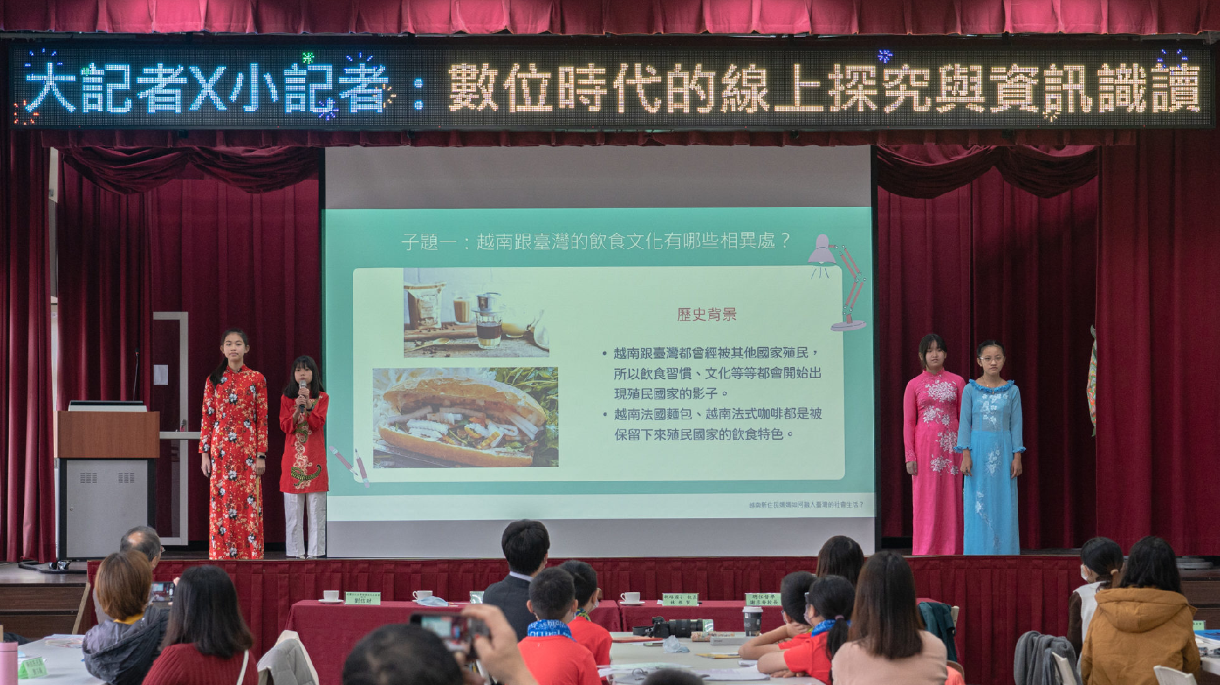 新路國小同學上台發表時，身穿著新住民媽媽替她們準備的越南傳統服飾「奧黛」（Ao Dai）。（攝影／陳星穎）