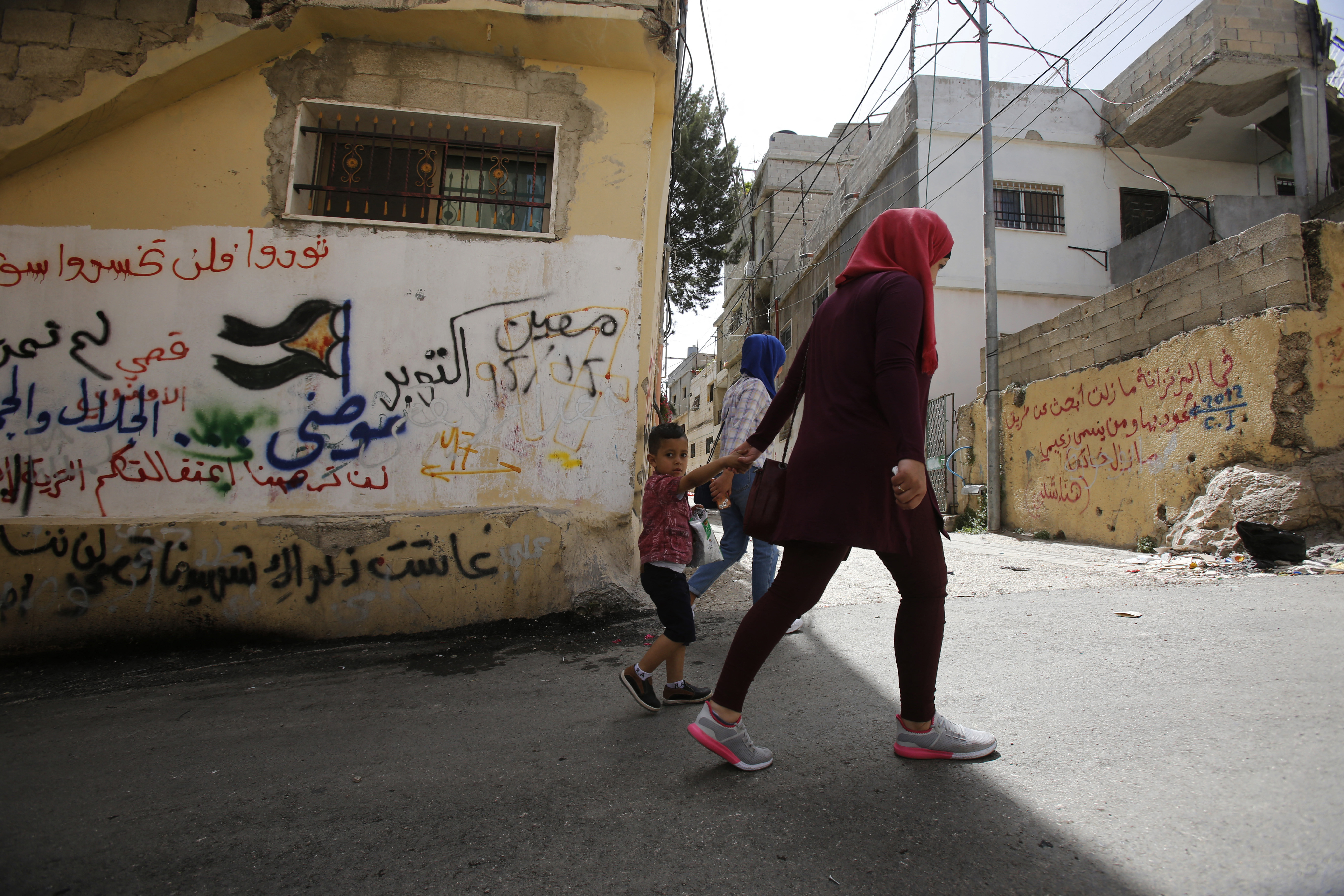 2017年5月,巴勒斯坦民眾走過狄黑旭難民營的街頭。(攝影/Musa AL SHAER/AFP)