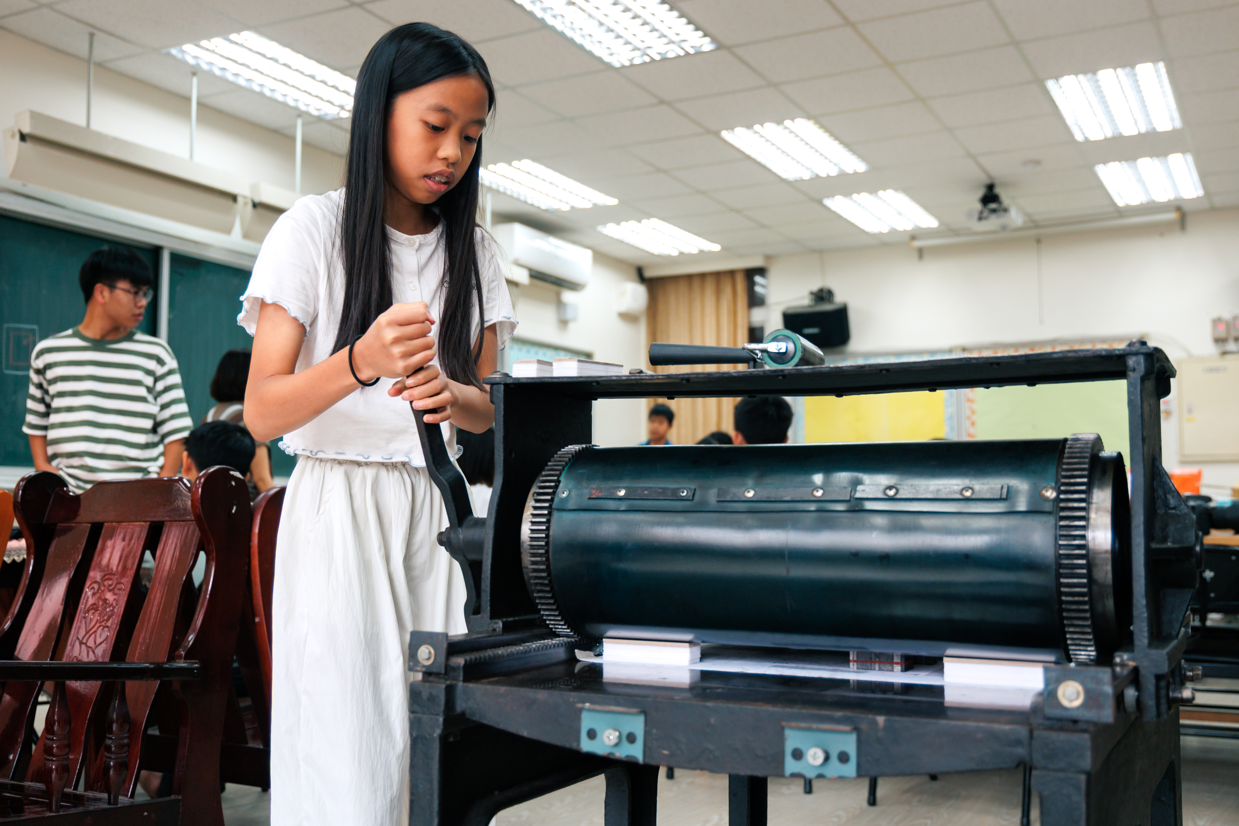 製作「赤峰景」影像小書時,同學們親手將活字排列的小詩對位於打樣機上,當握把轉動時,機器響起巨大的「隆隆」聲,也把字強而有力地印在紙面。(攝影/鄭宇辰)