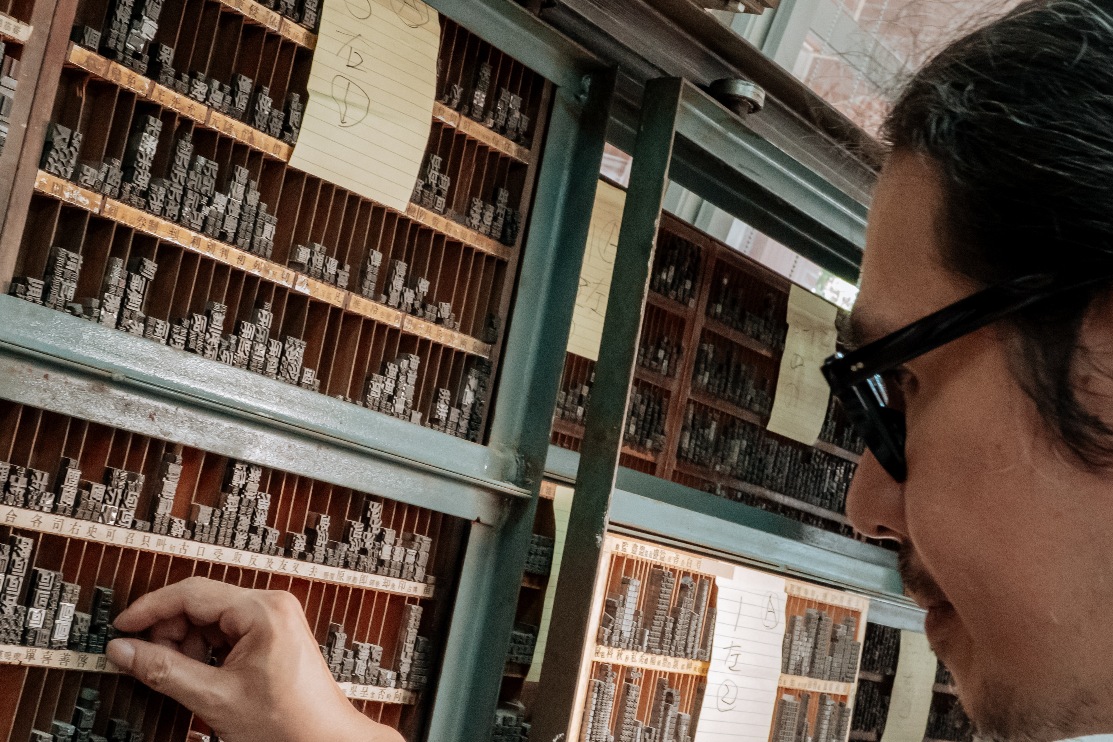 設計師高鵬翔與他費盡一番苦心、用心保留的字架，現存放於建成國中內。（攝影／李姿妤）