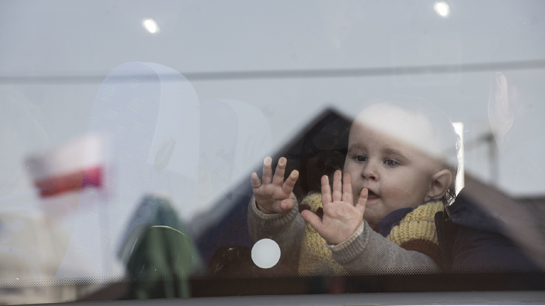在接近烏克蘭邊界的波蘭城鎮梅迪卡（Medyka），許多烏克蘭難民通過國界後在這裡搭上了前往其他城市的巴士。3月15日中午，一個孩子搭上車之後望著窗外的景色。（攝影／楊子磊）