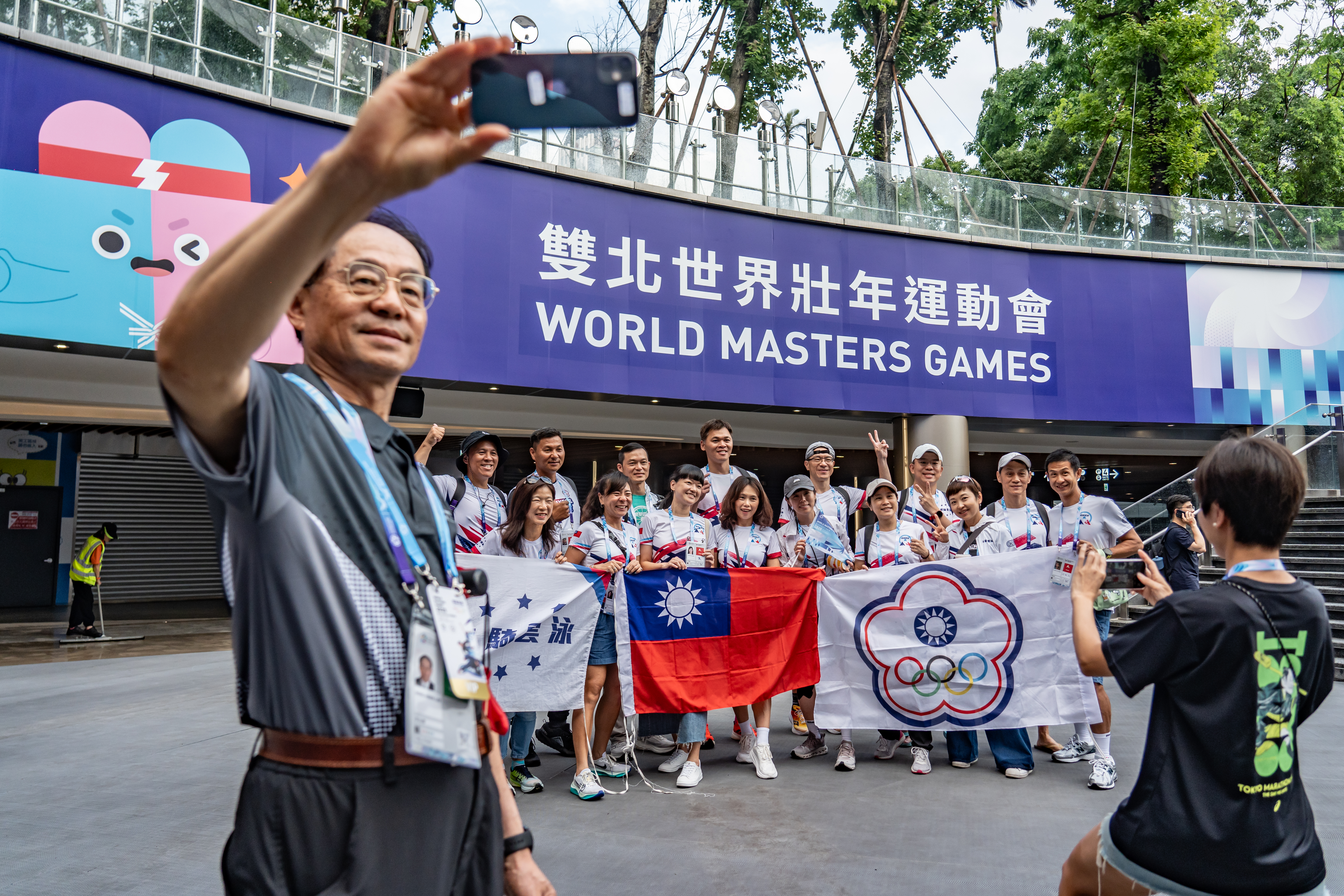 雙北世界壯年運動會開幕當天，參與者帶著國旗在現場打卡留念。（攝影／陳曉威）